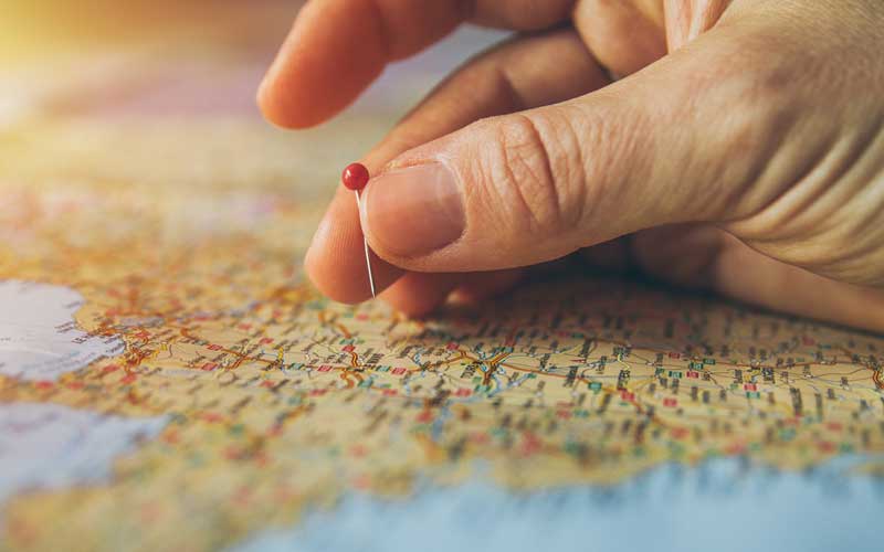 zoom sur un main plaçant une épingle sur une carte de France pour décider du lieu d'implantation des églises évangéliques baptistes