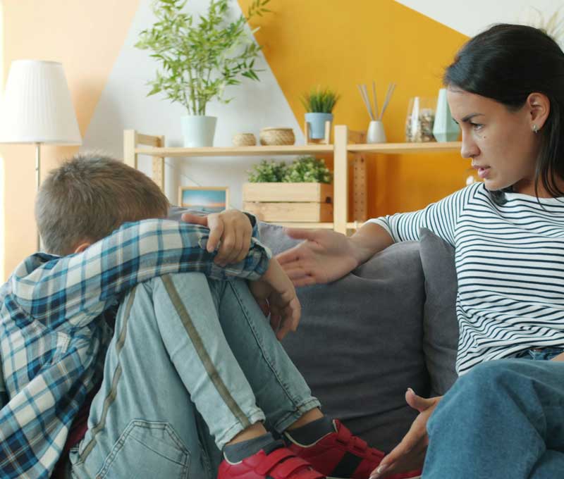 une femme dialogue avec un enfant qui semble bouder à l'église
